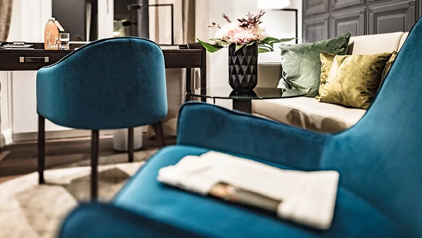 Vackra detaljer och accentfärger från hotellet. Stolar i petrolblått, soffor i beige och vackra blommor i vaser.