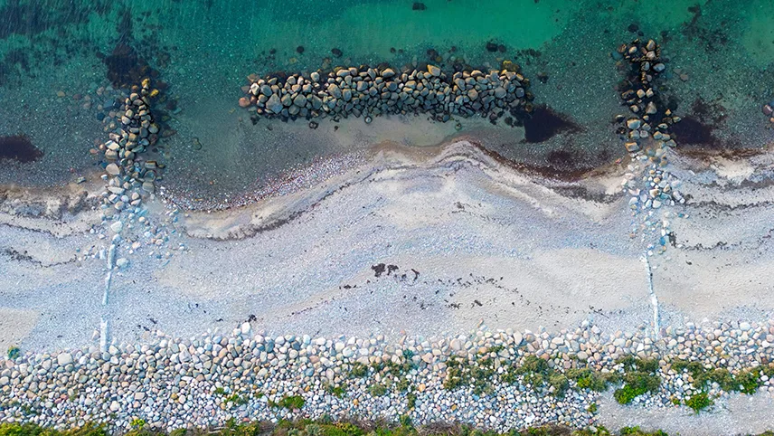 Flygfoto av strandremsa med stenar och hav på Gilleleje strand i Danmark.