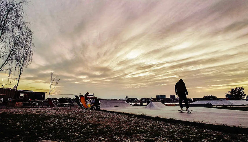 En skatepark på Reffen med en skateboardåkare som åker runt.
