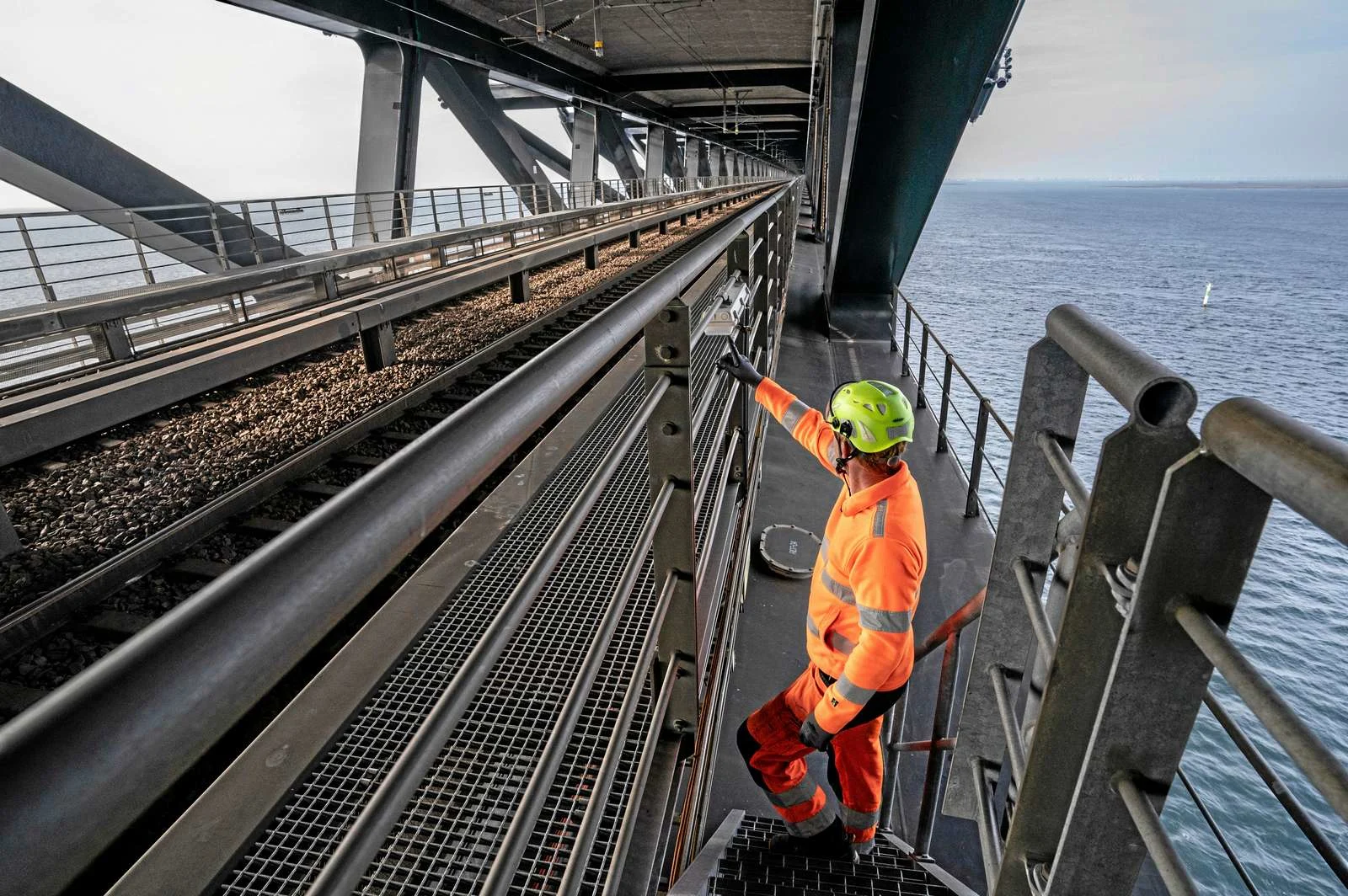 A man in safety gear and a hard hat working on the bridge