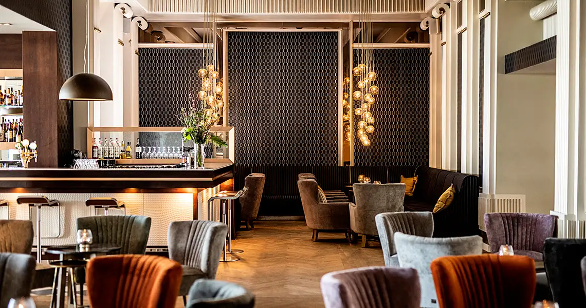 Barområde med sittplatser små bord på Marienlyst Strandhotel och Spa.