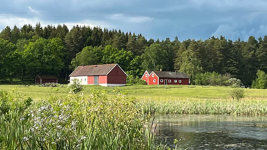 Rødt hus med lade foran søen ved Destination Snogeholm.