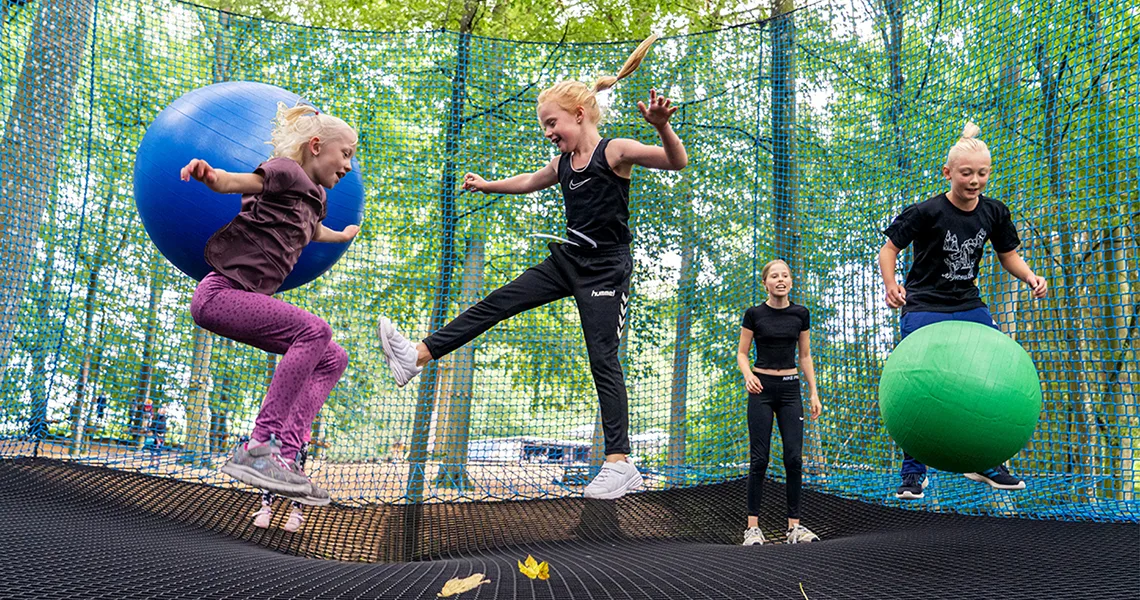 Fyra barn hoppar på en trampolin och leker med hoppbollar på Go Bounce.