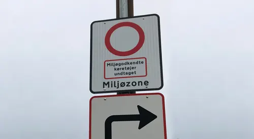 Dansk miljözonsskylt som markerar infart i miljözoner. Skylten har vit bakgrund, svart text och ytterkant samt en röd cirkel för att markera zonen.