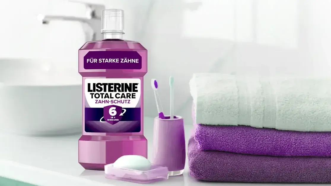 Eine Listerine Packung, zwei Zahnbürsten und drei Handtüchern.