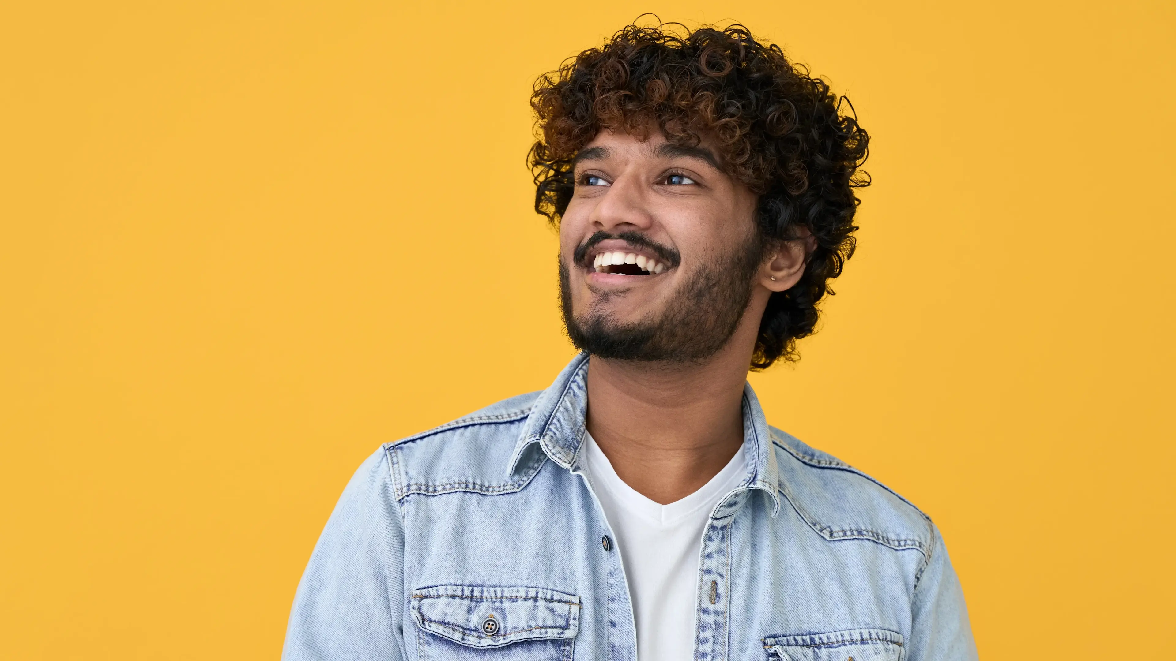 Ein lächelnder junger Mann, der nach oben schaut