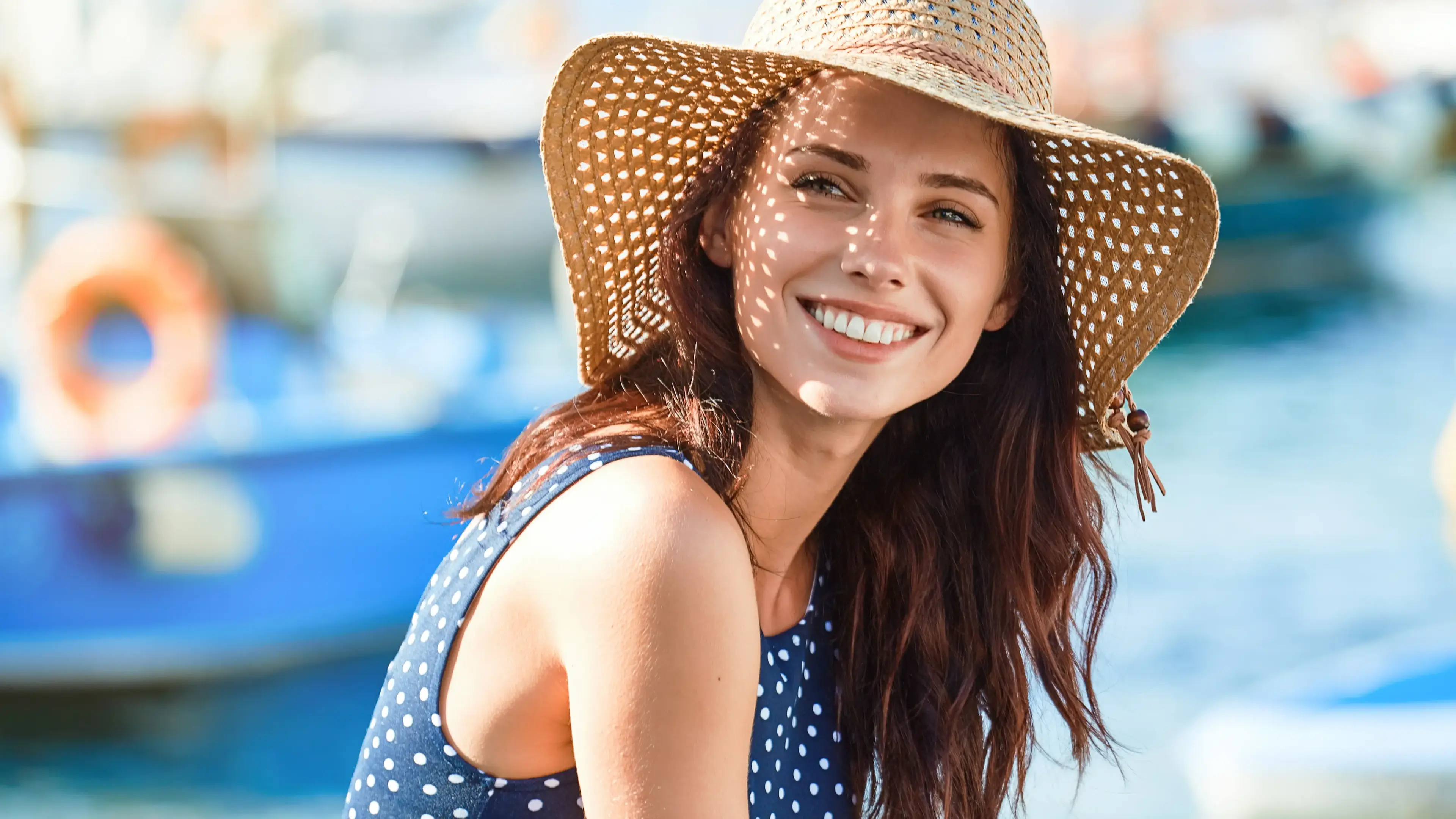 Eine lächelnde Frau mit Hut auf dem Kopf