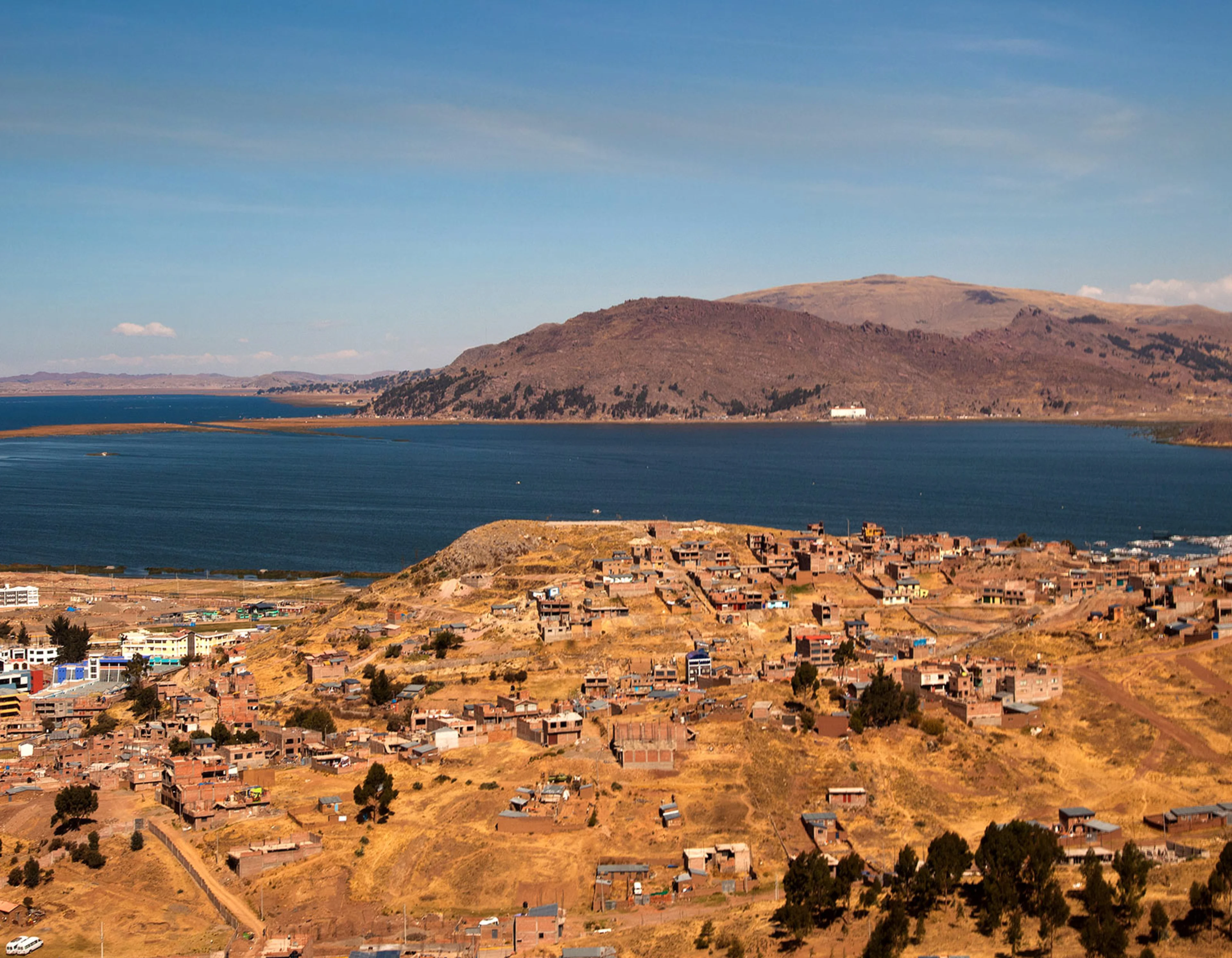 Houses in desert like surrounding in front of Lake Titicaca.