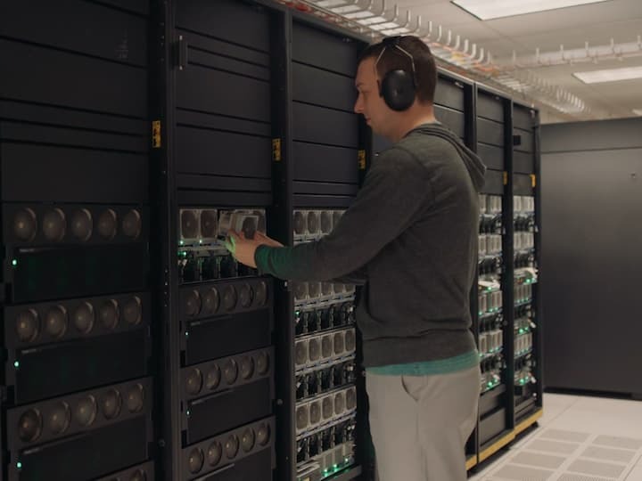 Man with headphones working on data center.