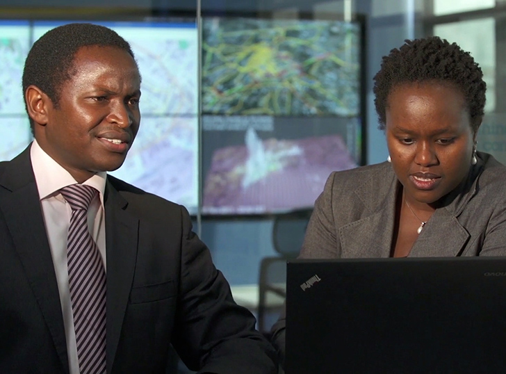 Un homme noir et une femme noire travaillant ensemble au bureau.