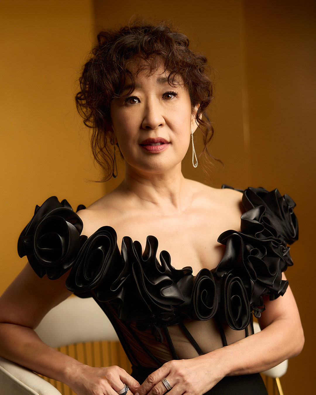 Portrait of Sandra Oh in a black off shoulder corset dress