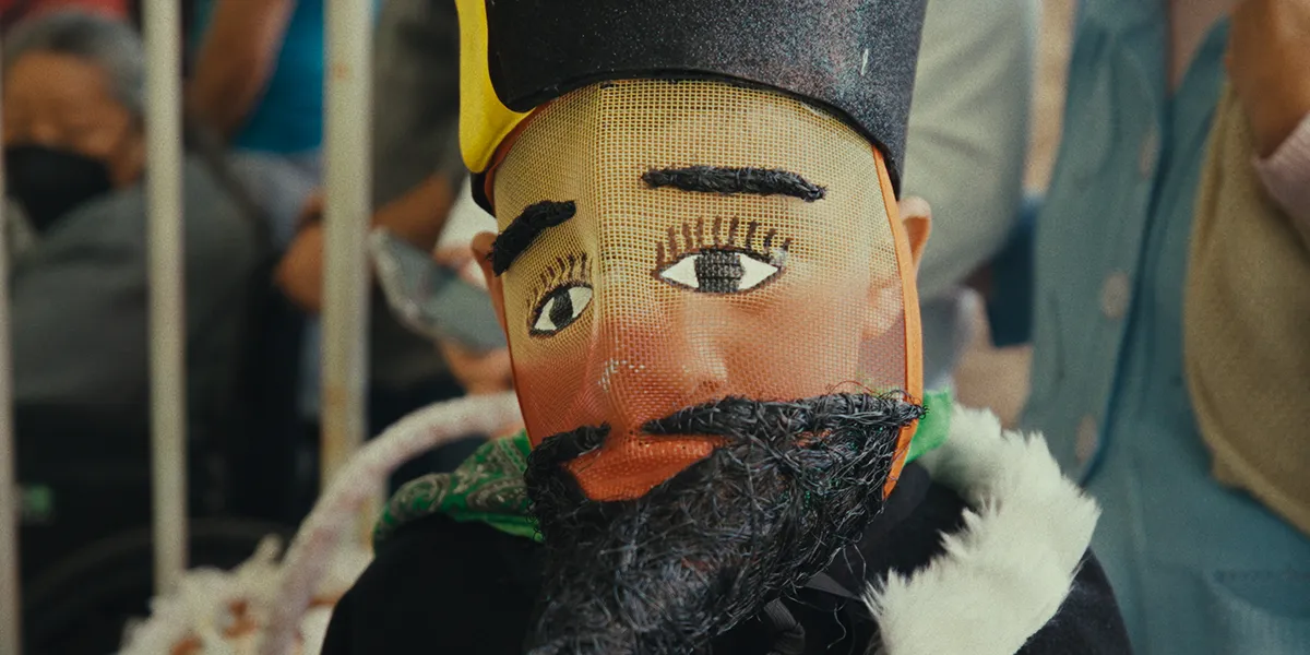 Traditional puppet with painted face, black beard, and top hat in close-up view