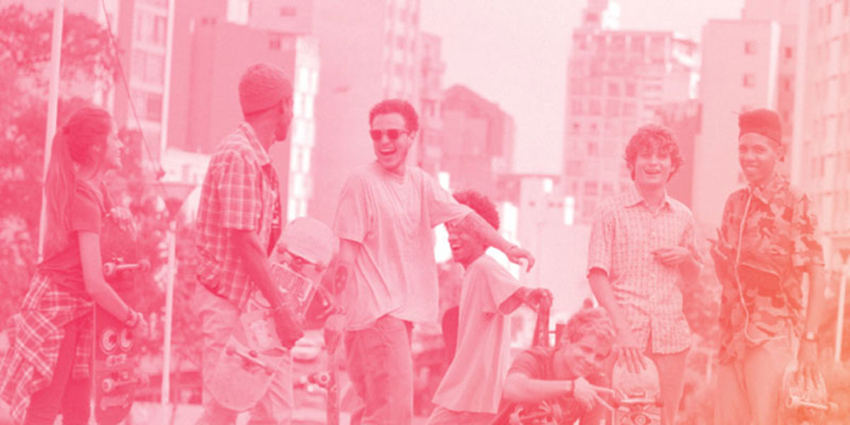 A group of teenage skateboards standing around and laughing