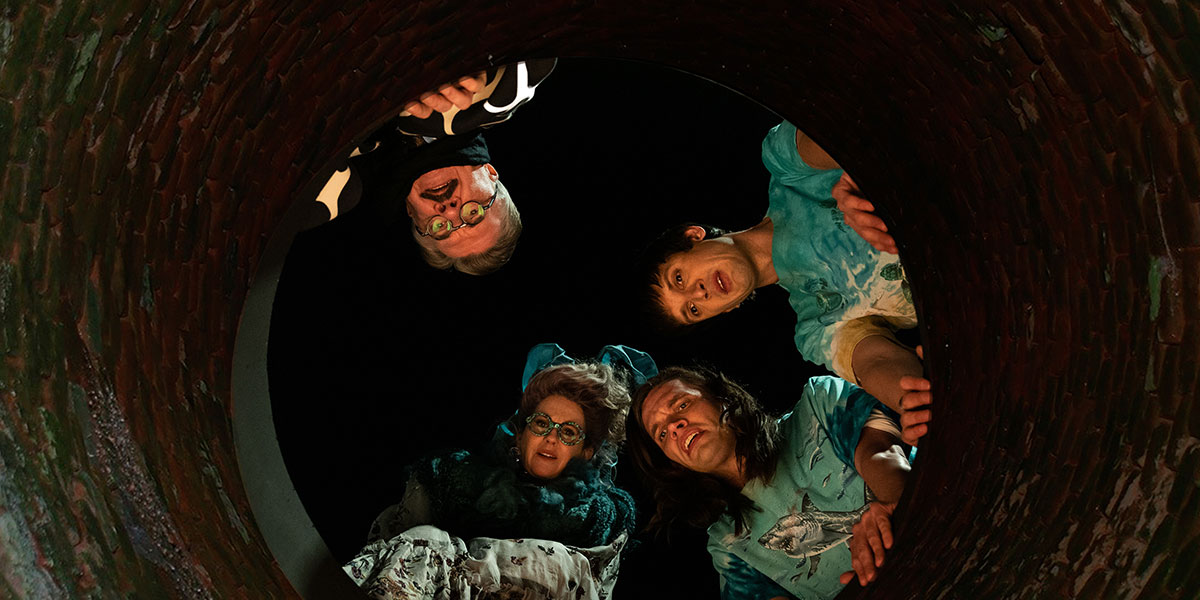 Four people looking down a huge hole in the ground