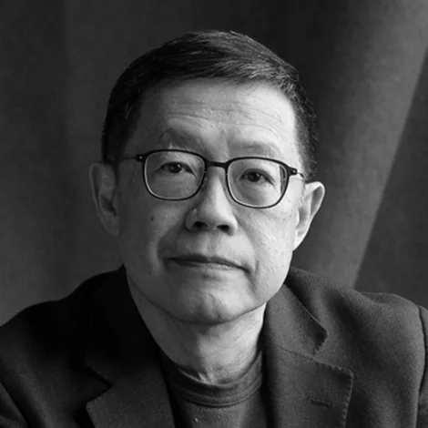 Black and white portrait of a middle-aged Asian man wearing glasses and a blazer.