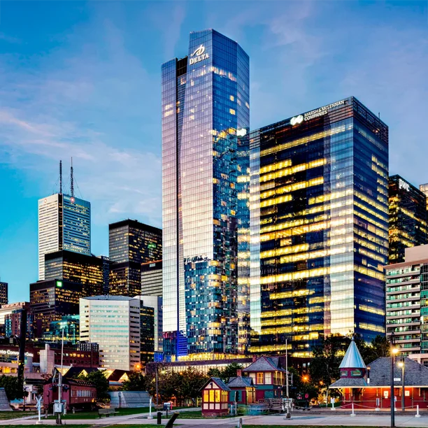 Modern Toronto skyline at dusk with illuminated skyscrapers and colourful historic buildings in foreground
