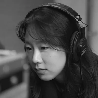 Person wearing headphones in a black and white profile shot, looking thoughtfully to the side