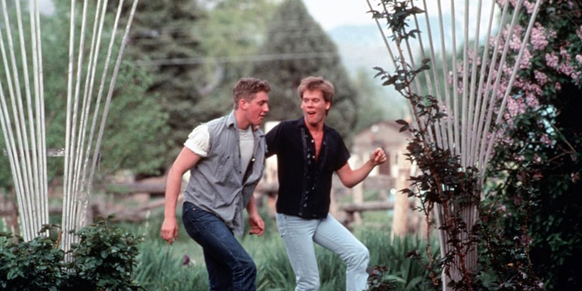 Kevin Bacon and John Laughlin dancing in the field