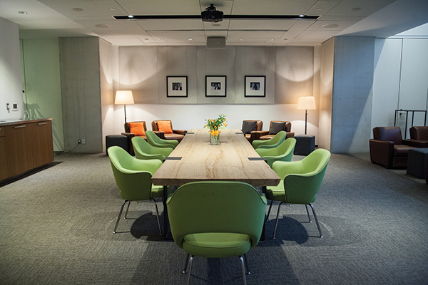 Interior shot of The Green Room with a long wooden table and green chairs around it