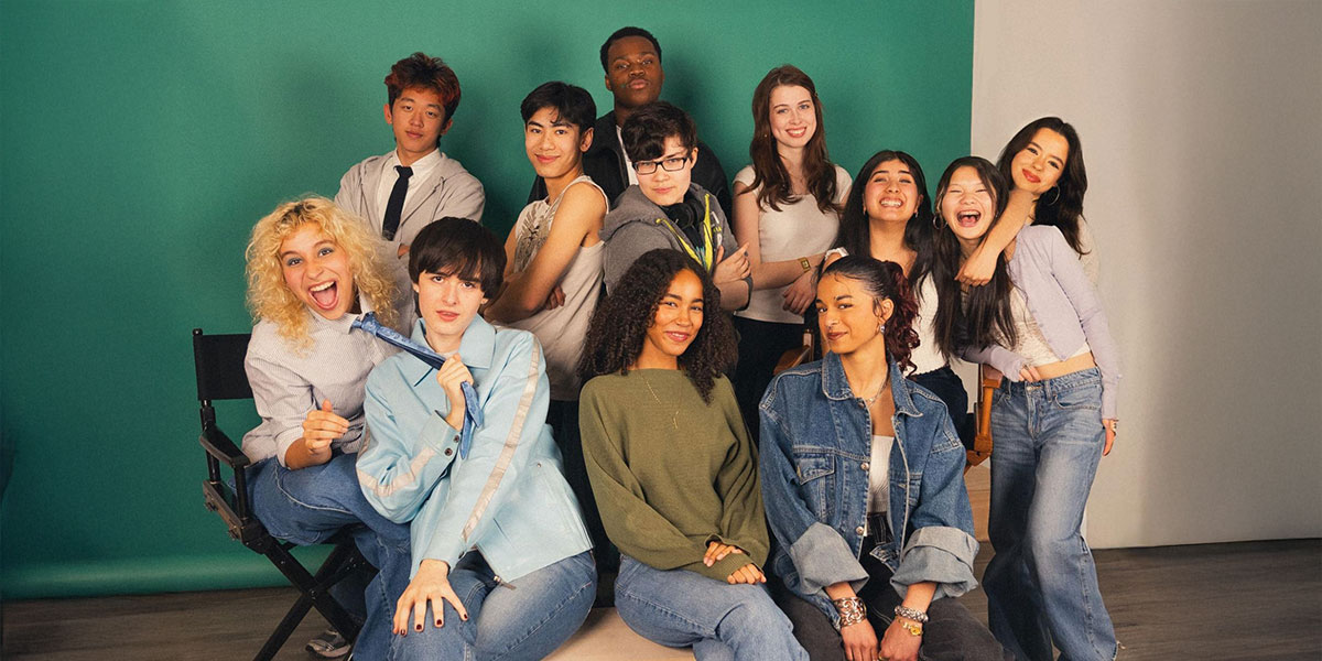 A group of teens forming the Next Wave committee having fun and posing for a photo together in front of a green screen