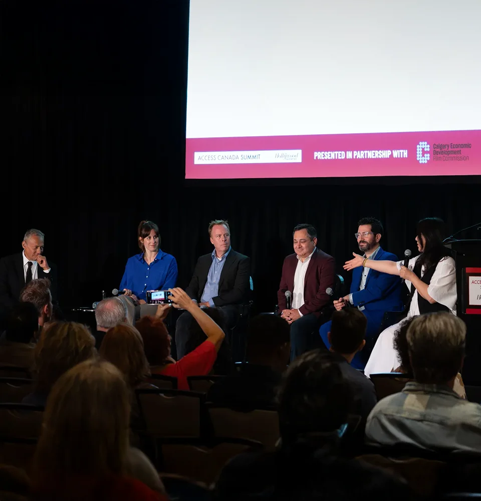 Five panelists seated on stage at the Access Canada Summit, speaking to an audience.