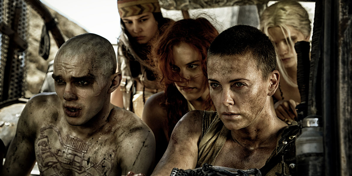 Furiosa (Charlize Theron) amongst a group of people in a car