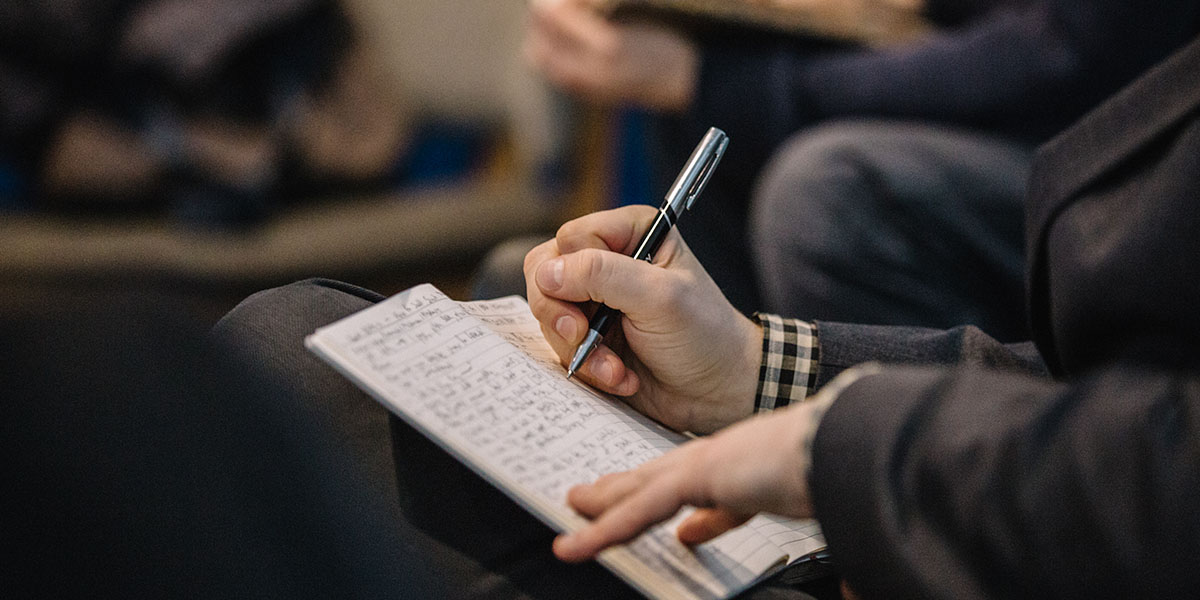 A person writing down notes into a journal