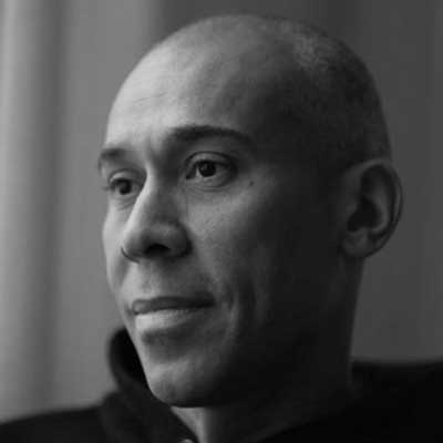 Black and white close-up portrait of a person with a contemplative expression looking to the side