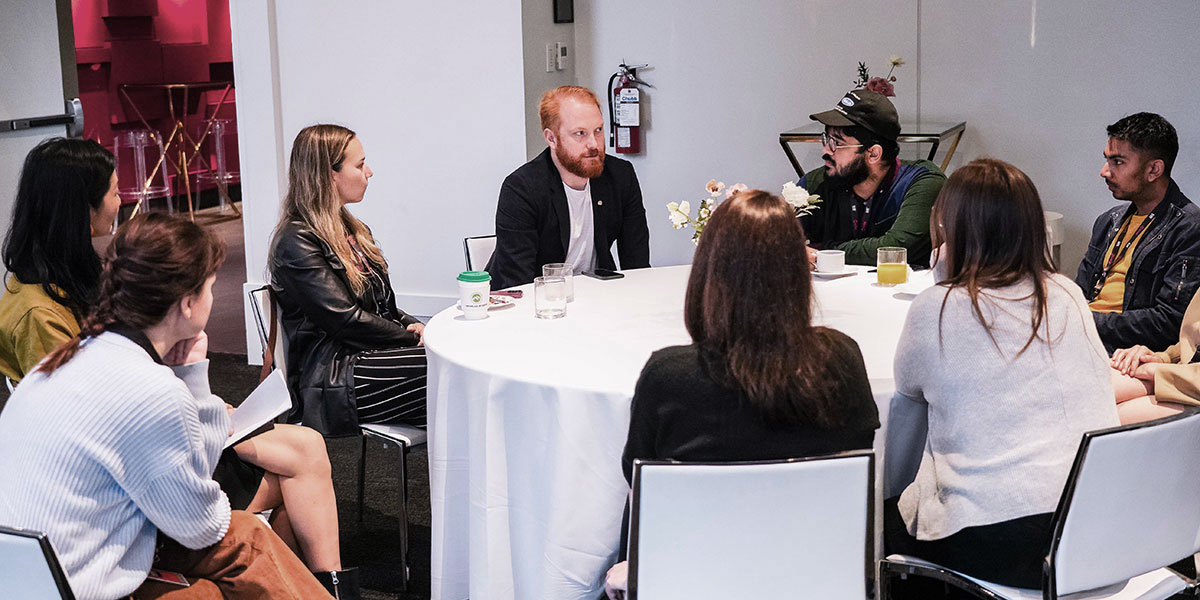 A group of people in discussion over a round table