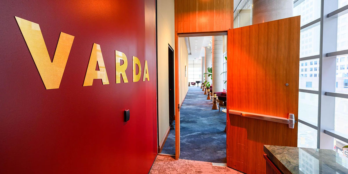 Entrance to Varda, with its name in gold against a red wall