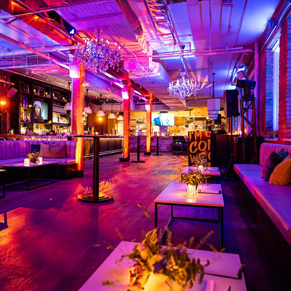 Interior shot of a bar at MARBL Toronto bathe in pink lighting