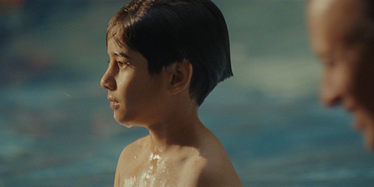 An Afghan boy looking towards the left after coming up from the water