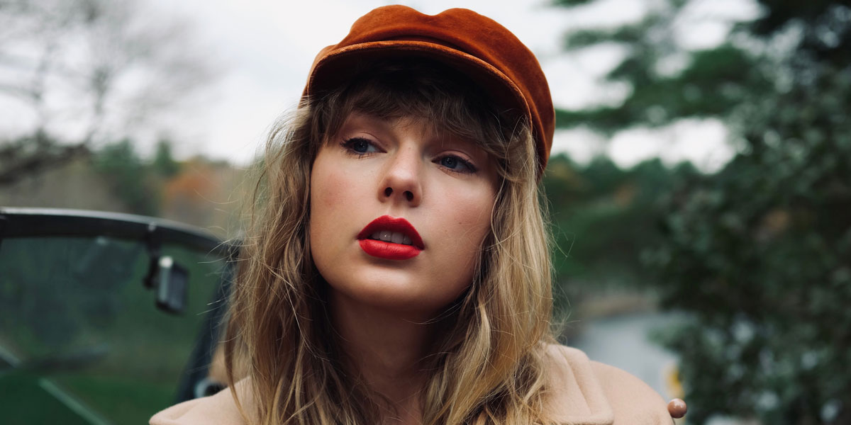 Portrait of Taylor Swift wearing a red hat in a car