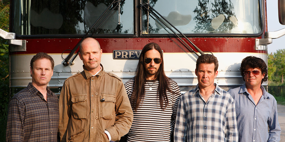 The Tragically Hipp standing in front of their tour bus