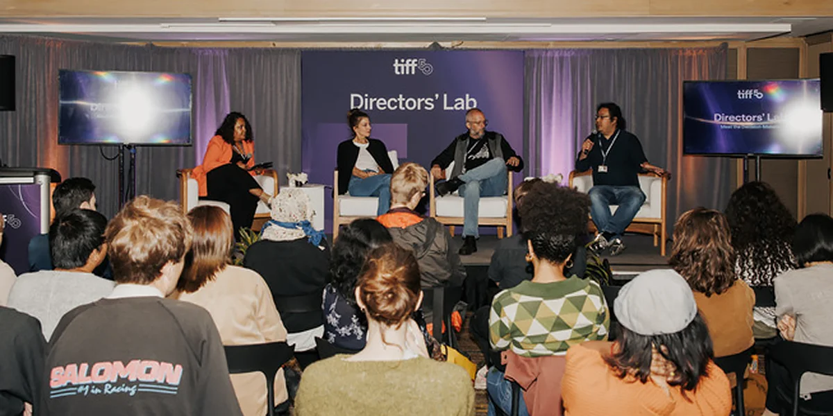 Panel discussion at TIFF Directors' Lab with four speakers on stage addressing a seated audience