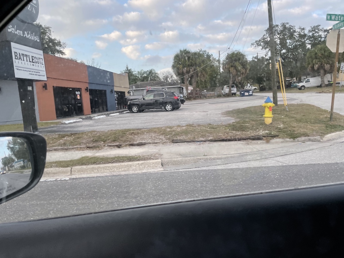 A street, as seen from the passenger seat of a moving car. This photo contains EXIF metadata - see if you can find the speed at which the photographer was moving when it was taken!