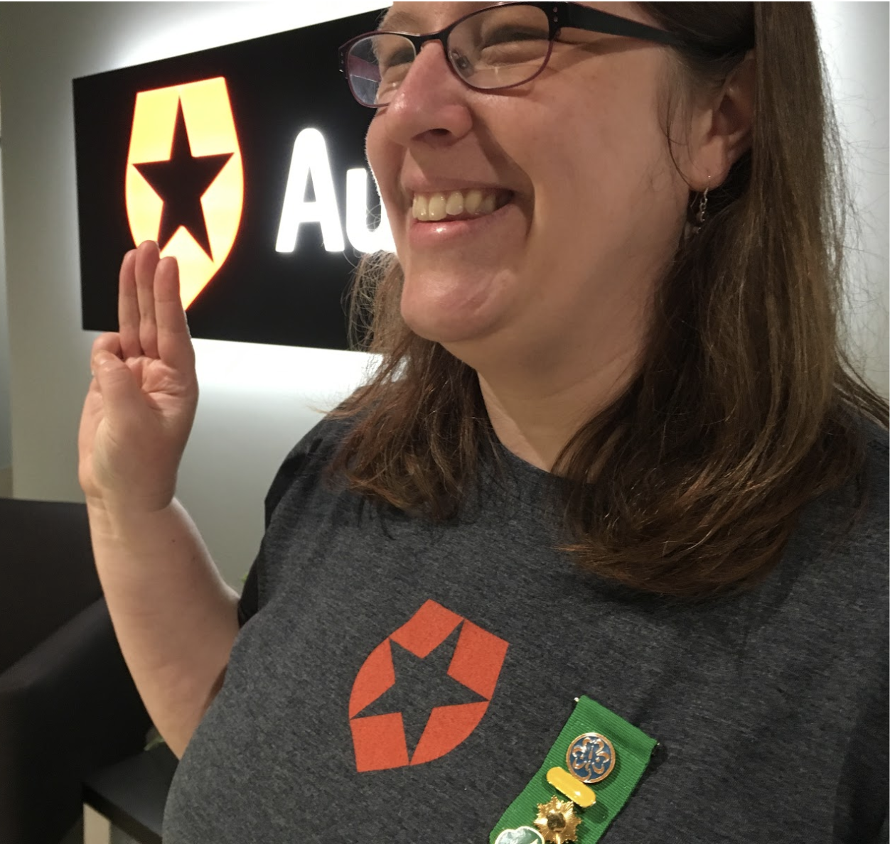 Auth0 Support Operations Manager Abigail Sanchez showing Scout Sign Salute with badges of Scout accomplishments