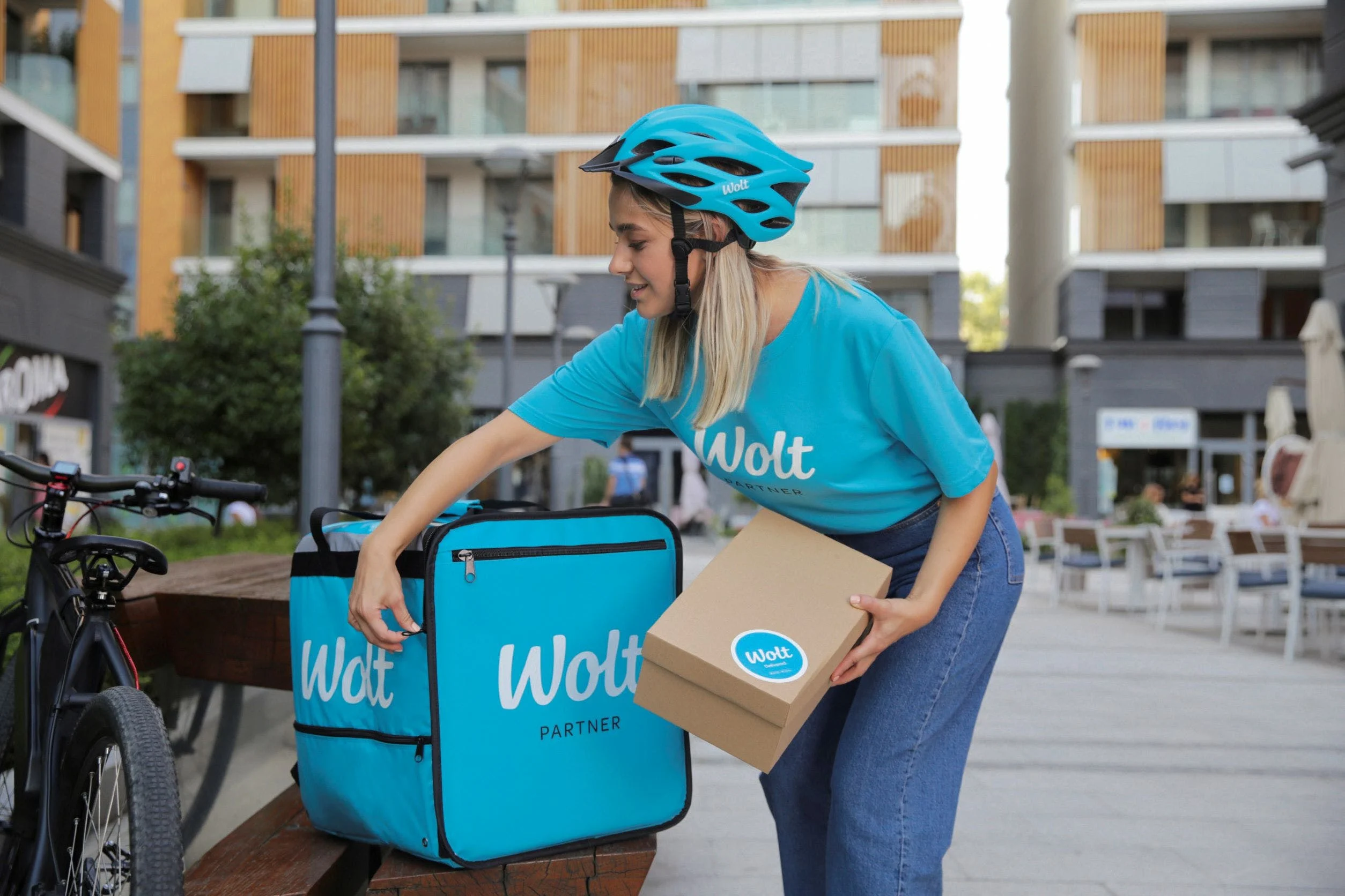 Wolt courier partner placing box into wolt bag