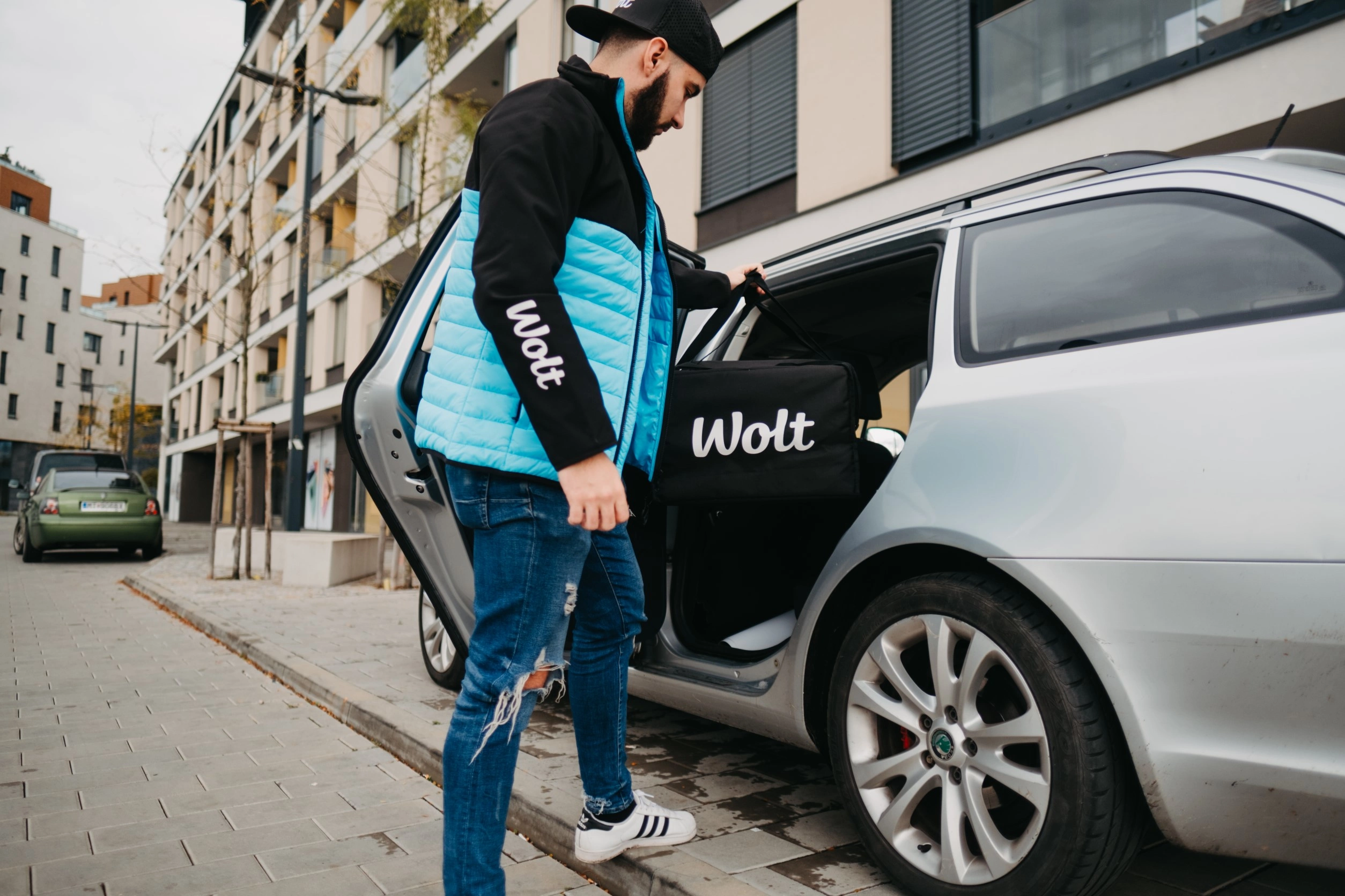 Wolt courier partner placing bag into a car