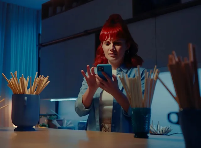 A hi-res photo of a woman receiving a notification. Used for Product Safety Recalls at Wolt page.