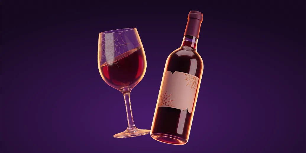 Red wine bottle and glass decorated with orange spiderwebs on a dark purple background, representing Halloween wine and drinks delivery with Wolt.