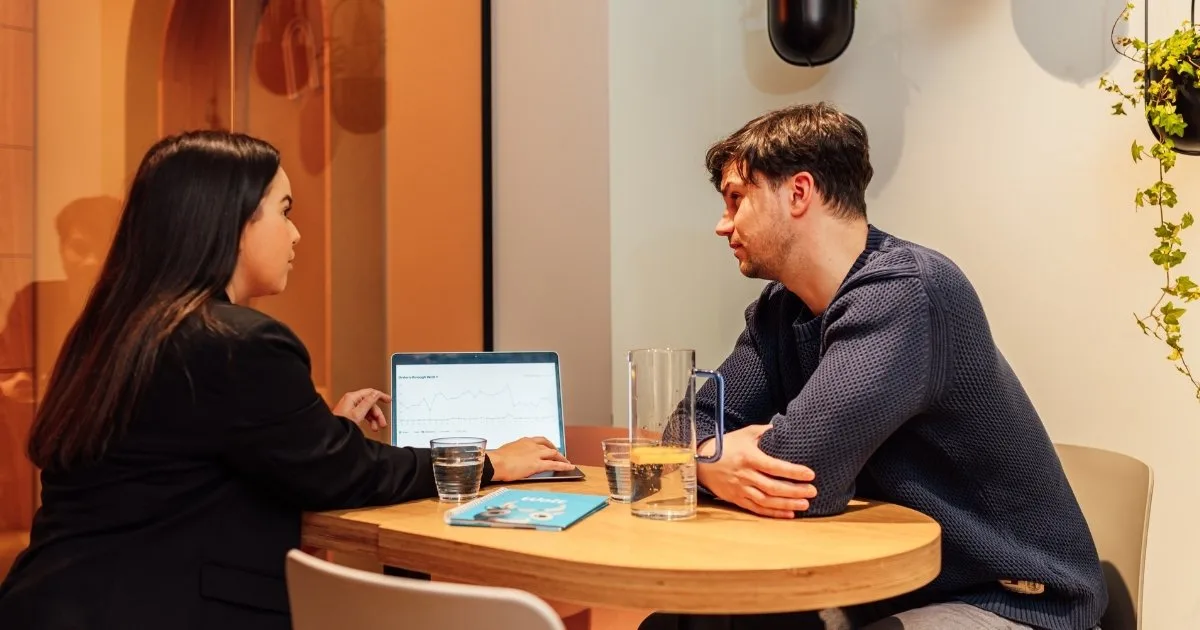Zwei Kollegen prüfen Kampagnendaten und Leistungstrends einer Liefer-App auf einem Laptop, bevor sie ihre nächste Restaurant-Werbekampagne starten