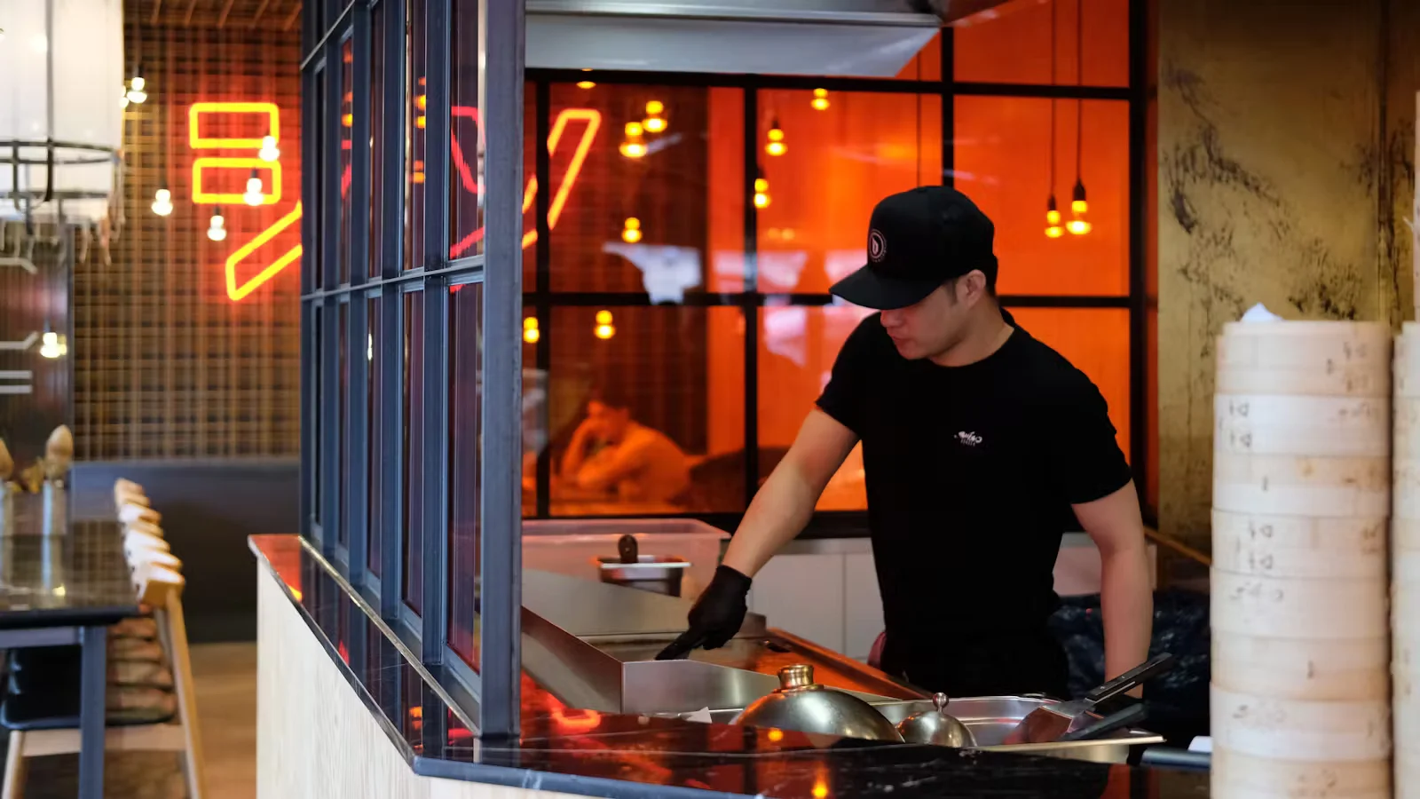 Cook preparing orders at Shiso Burger’s kitchen.