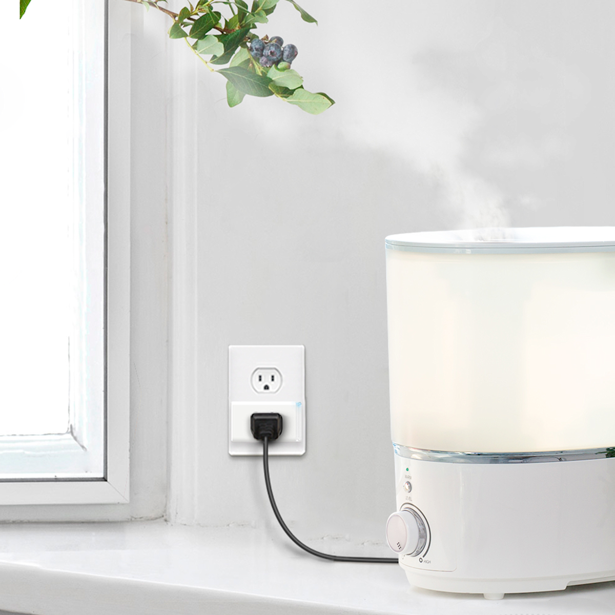 Photo de mode de vie avec une prise intelligente Mini de Kasa branchée dans une prise murale et un humidificateur branché sur la mini prise.