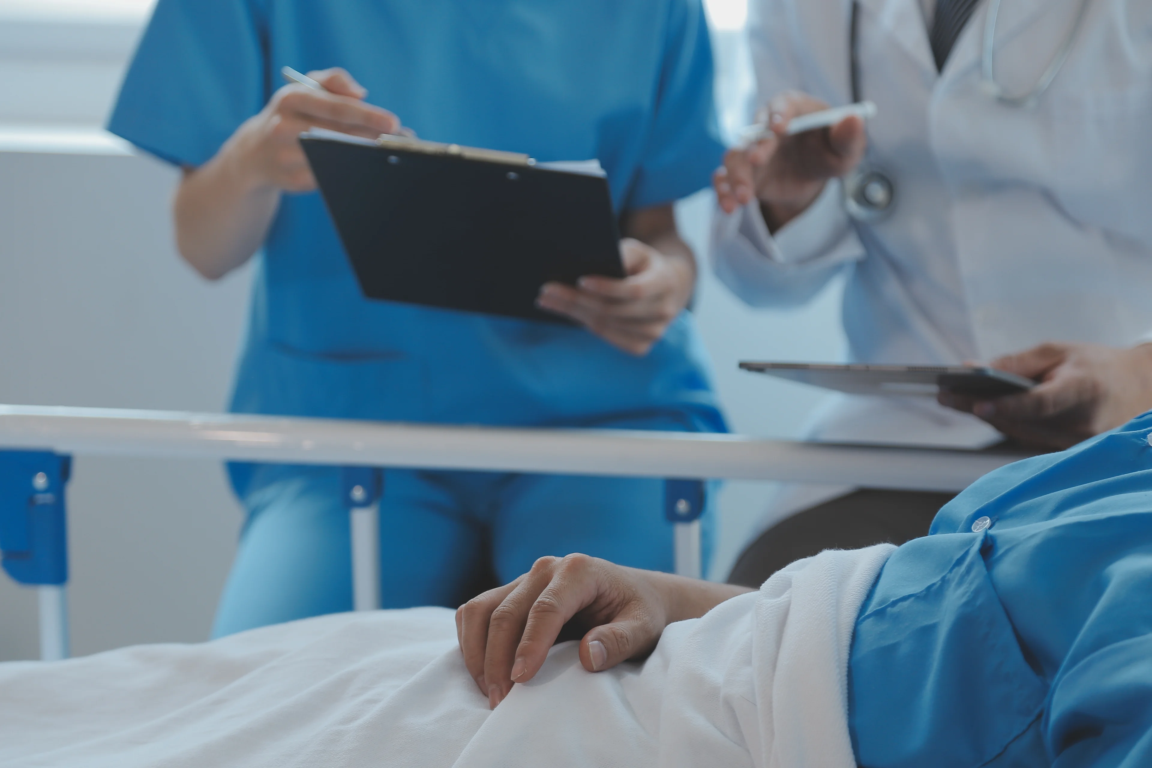 A doctor and a nurse look after a patient in an emergency room.