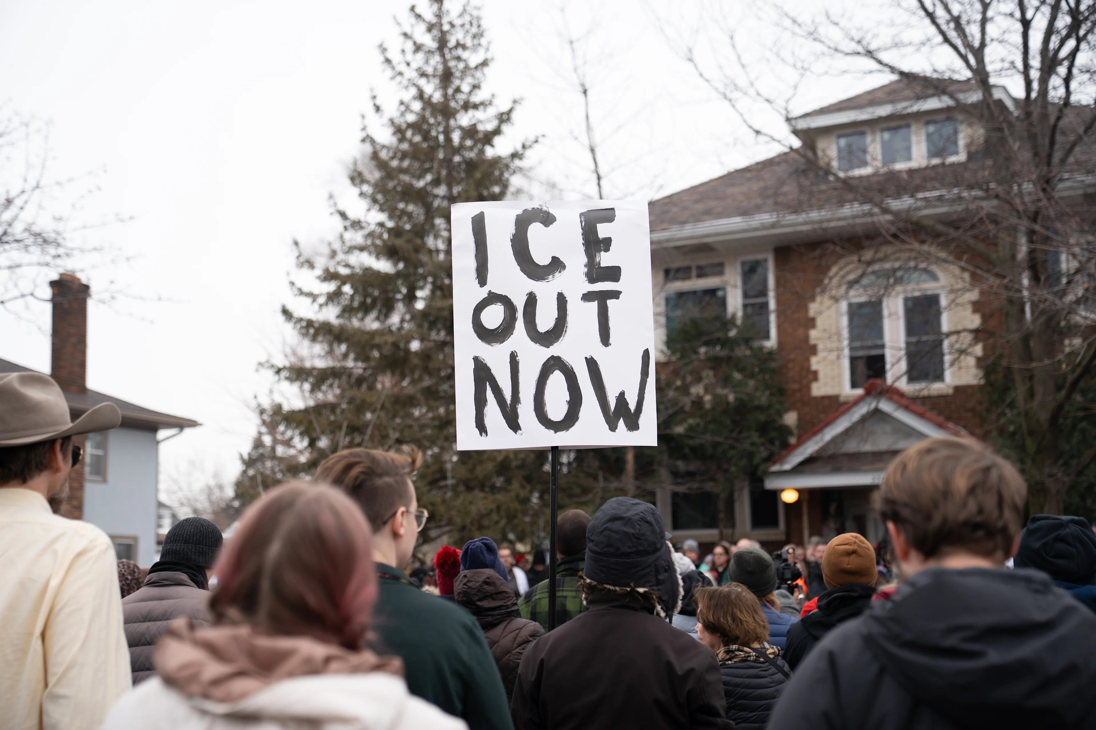 A person holds a sign in a group of protestors