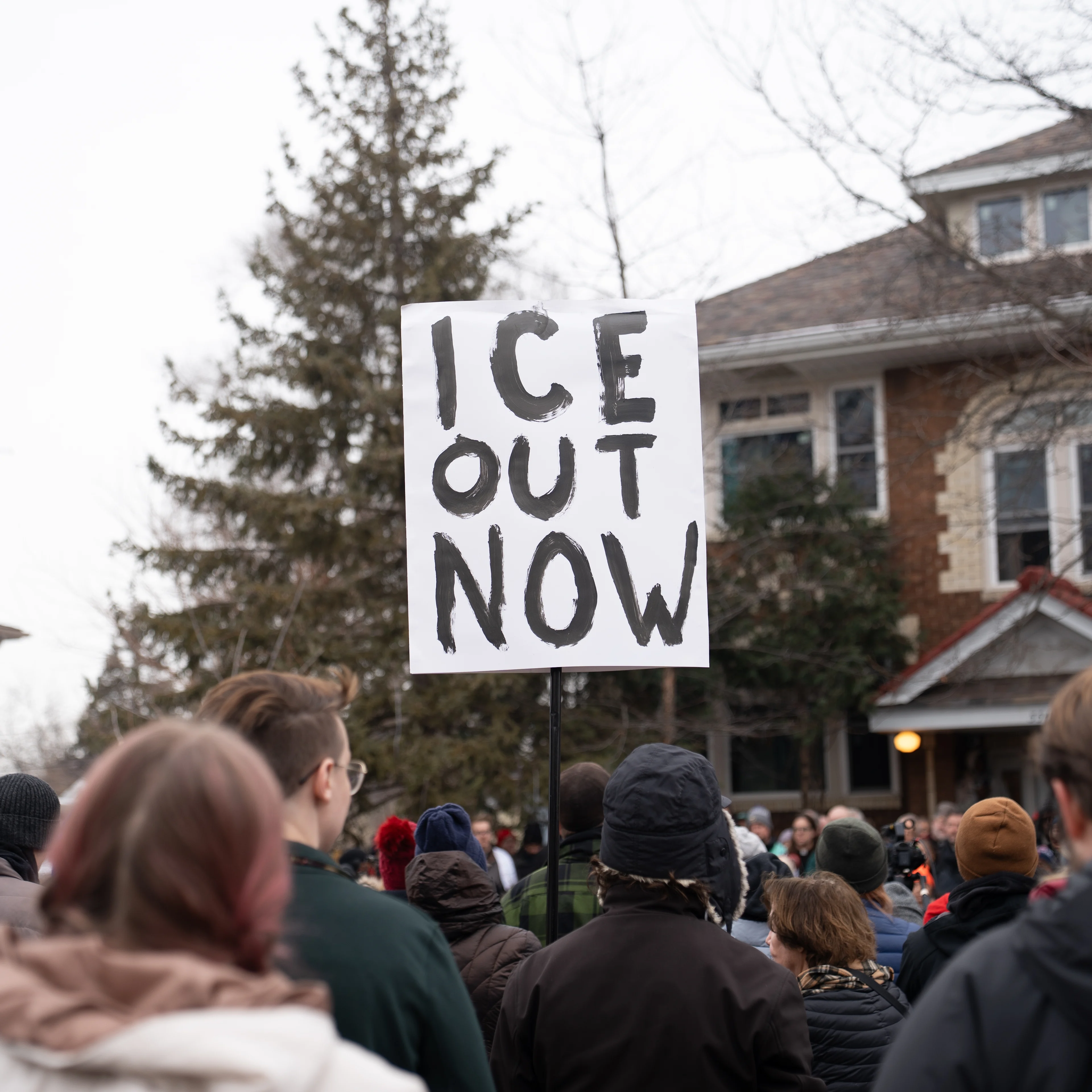 A person holds a sign in a group of protestors