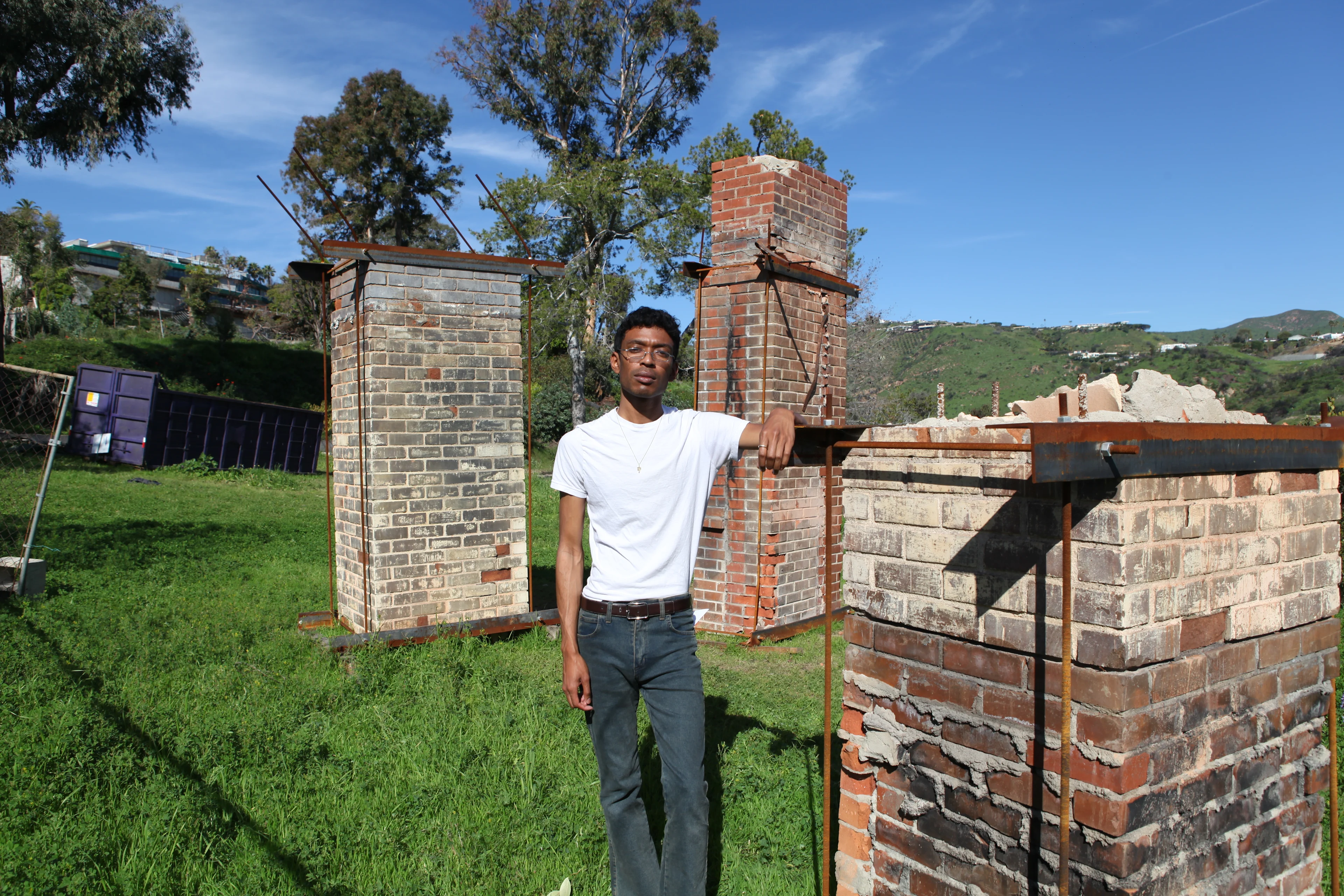 House Museum director Evan Curtis Charles Hall stands amongst three of the relocated chimneys .