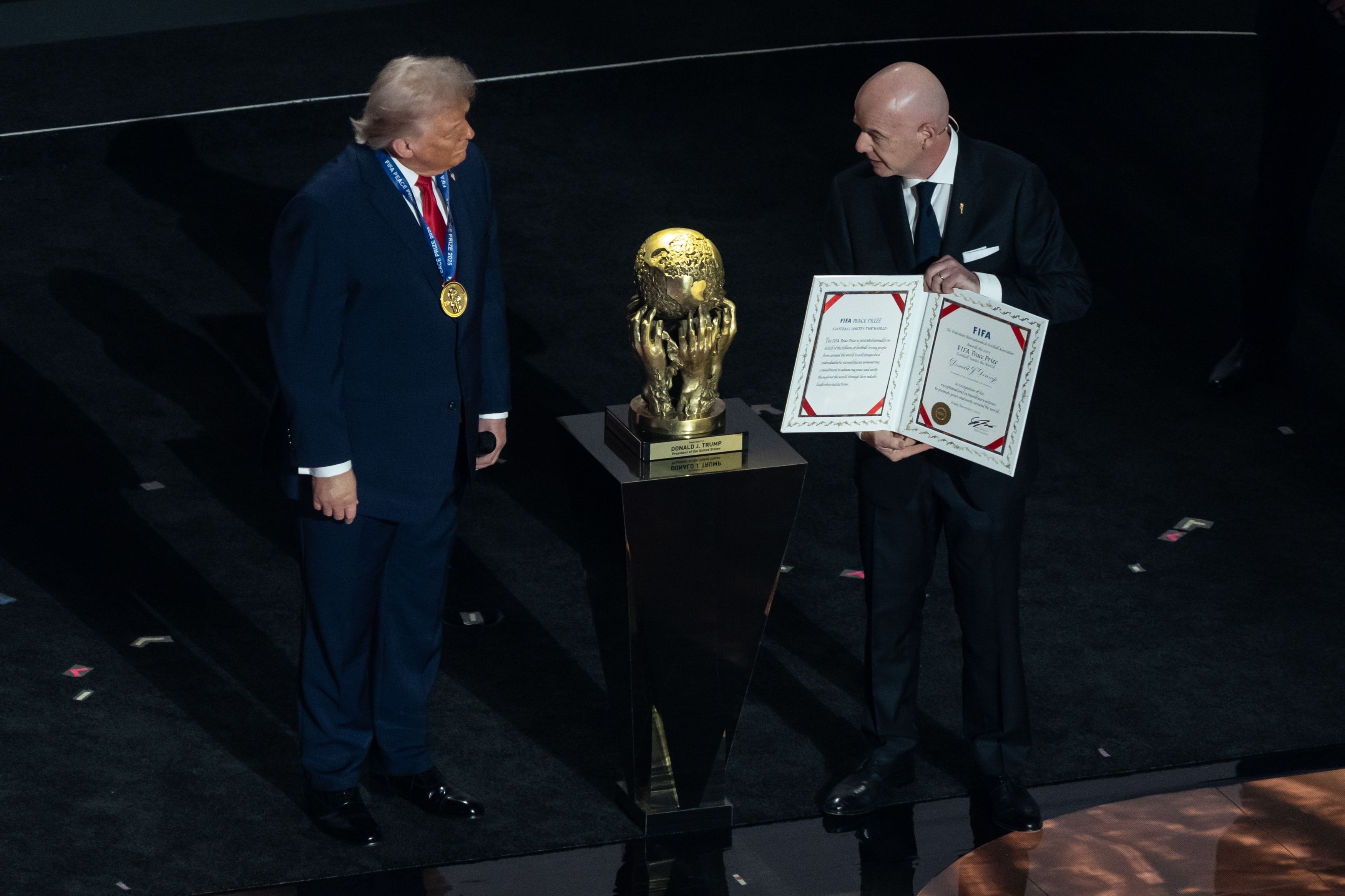 A bald man presents an award to another man