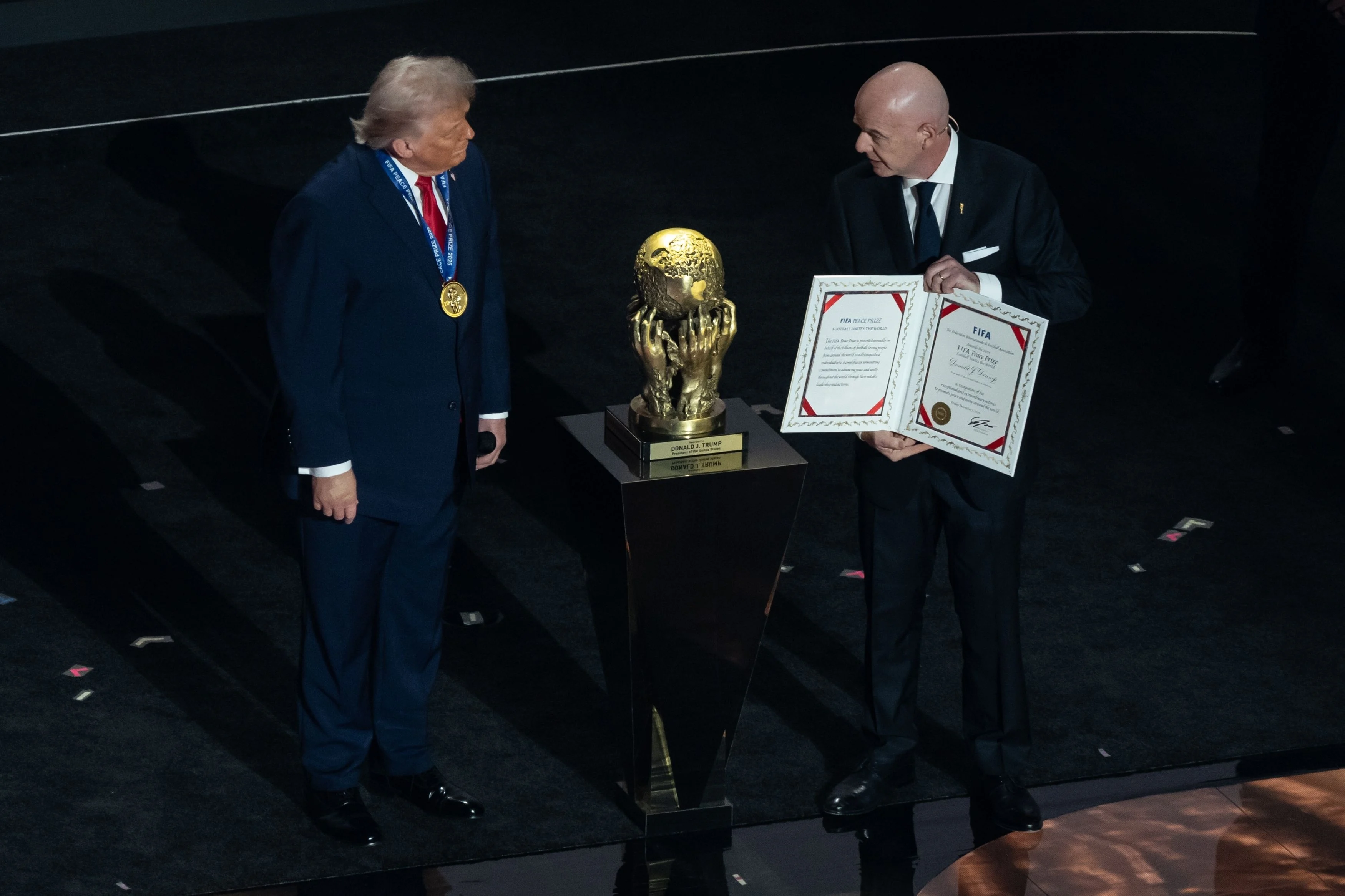 A bald man presents an award to another man